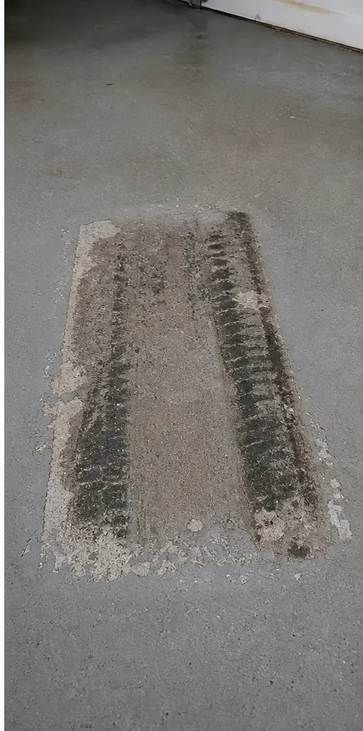 Tire-zone coating failure and rubber transfer on a garage floor